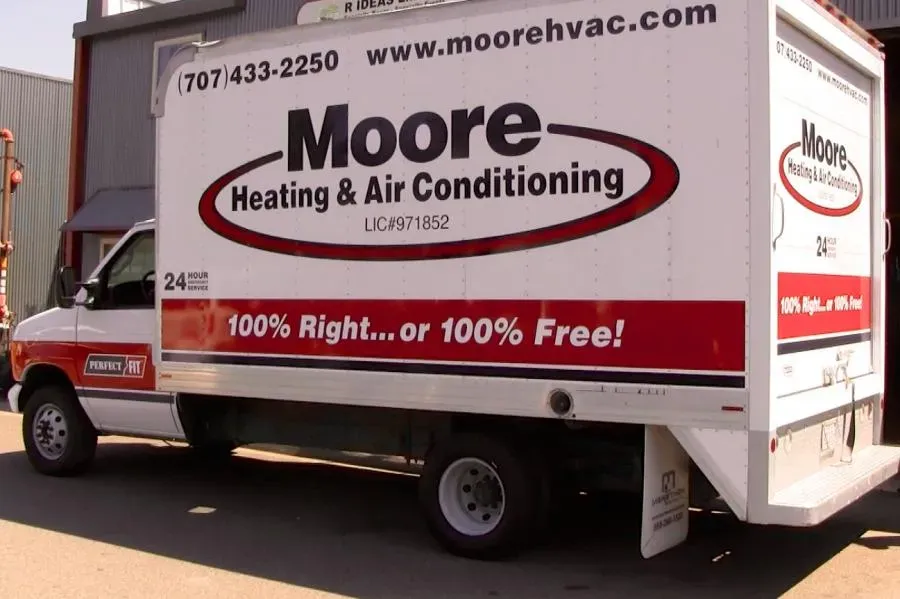 A Moore Heating & Air Conditioning service truck parked outside, displaying their slogan "100% Right...or 100% Free!" and contact details.